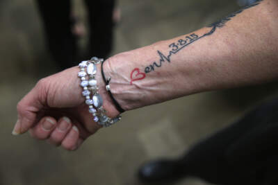 A Connecticut mother, whose son died of a heroin overdose in 2015, displays a tattoo to members of a family addiction support group in 2016. She got the tattoo to commemorate the year anniversary of his death. (John Moore/Getty Images)