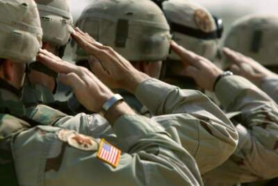 U.S. Army soldiers salute during a memorial service. (Photo by John Moore/Getty Images)