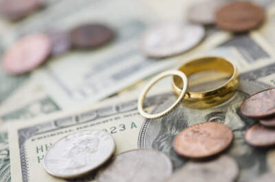 Close up of wedding rings with money. (Jamie Grill/Here & Now)