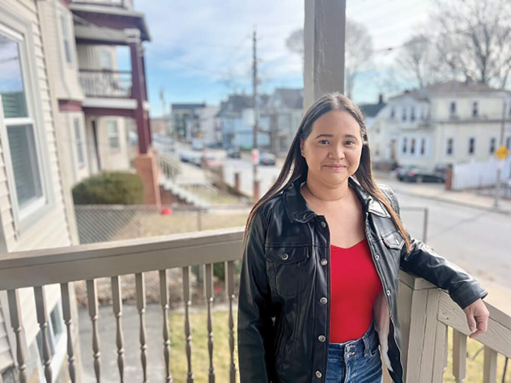 Jennifer Torres on the first-floor porch of the three-decker in the Bowdoin-Geneva area housing the condo unit that she hopes to close on by the end of the month. (Cassidy McNeeley/Dorchester Reporter)