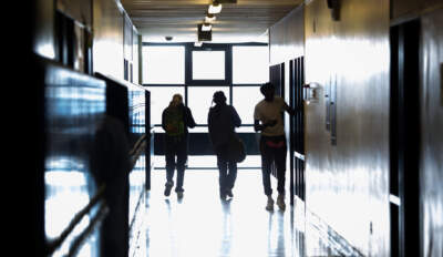 Students in silhouette near the entrance of Brockton High School. (Robin Lubbock/WBUR)