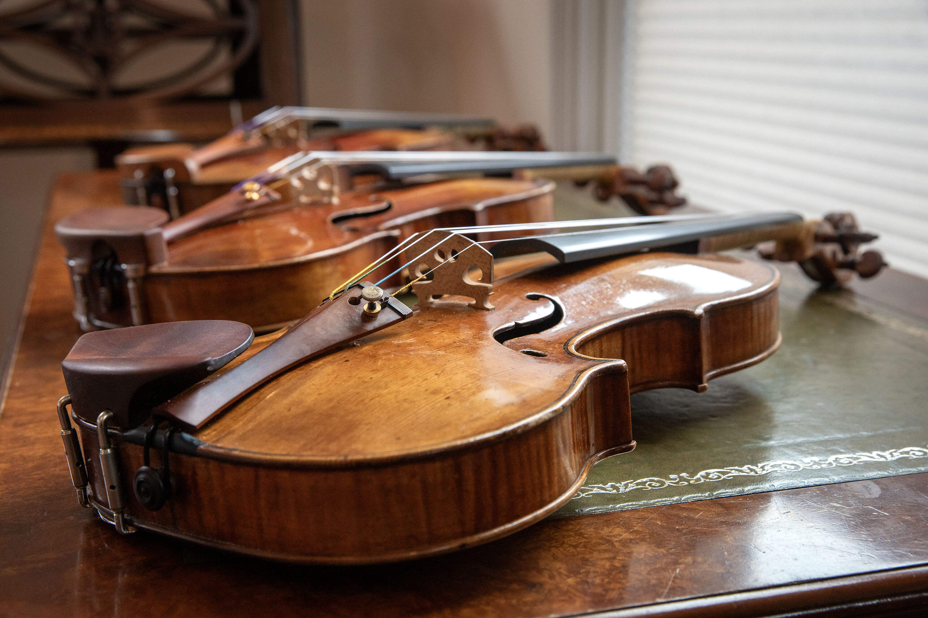 A Nicolo Amati violin, made circa 1645, and two others wait to be tried out by musicians from &quot;A Far Cry&quot; at Reuning &  Son in Brookline. (Robin Lubbock/WBUR)