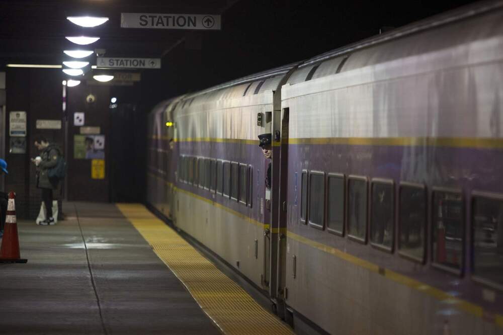 An MBTA conductor looks out the door as the Commuter Rail train leaves Back Bay Station. (Jesse Costa/WBUR)