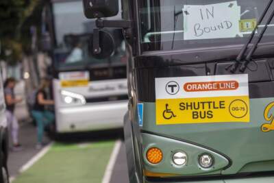 Commuters board a shuttle bus during the full closure of the Orange Line in 2022. (Jesse Costa/WBUR)