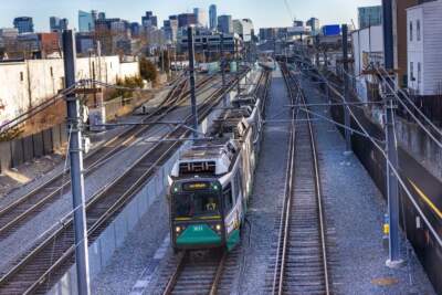 An MBTA Green Line train runs along the tracks. (Jesse Costa/WBUR)