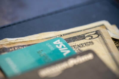 U.S. currency and credit cards sit on a table. (Jenny Kane/AP)