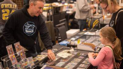A card vendor shows his collectible wares to a child at the Northeast Sports Card Expo. (Photo by Shawn Harding and Shawn Kreckie)