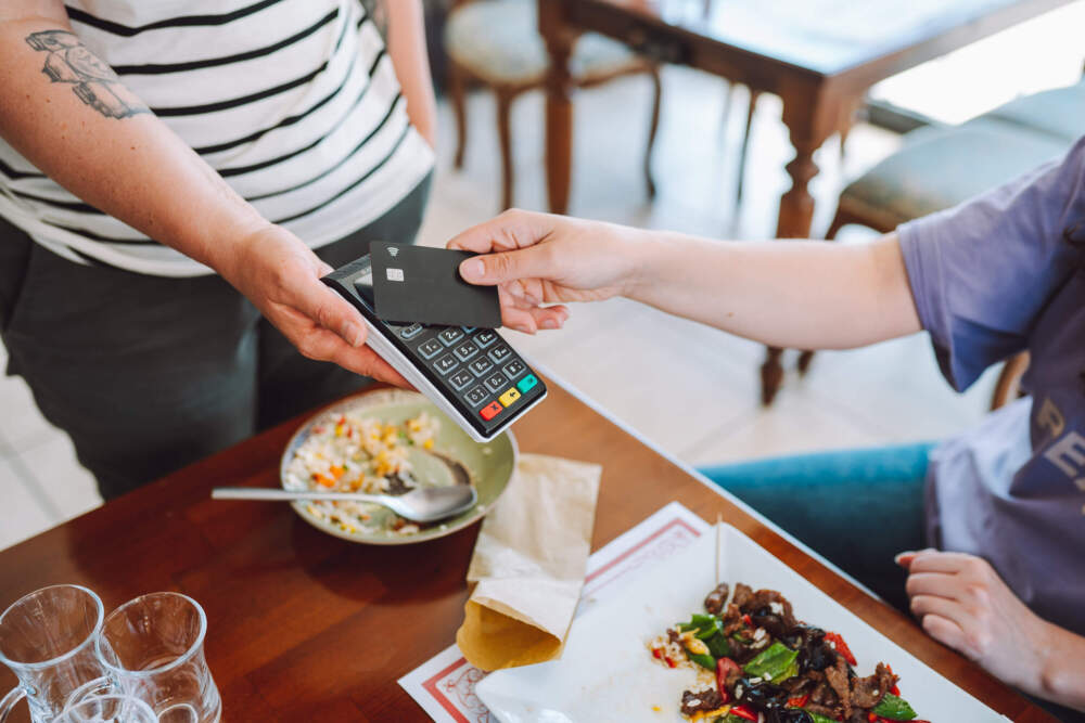 A restaurant patron pays for their meal. Only 4% of restaurants levied cancellation fees in 2019; now that's up to 17%.(Olga Rolenko/Getty Images)
