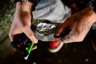 A person is using fentanyl on Park Avenue following the decriminalization of all drugs in downtown Portland, Oregon on Jan. 23, 2024. (Patrick T. Fallon/AFP via Getty Images)