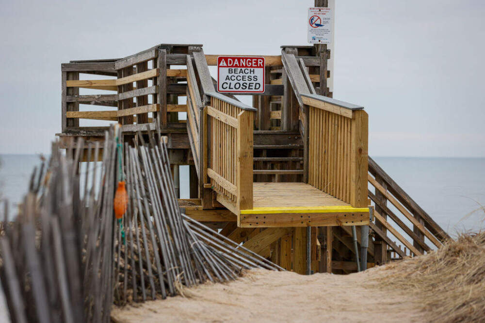 Crews work at Salisbury Beach in February to tear down wooden staircases over the sand dunes that were damaged by storms in December and January. (Erin Clark/The Boston Globe via Getty Images)