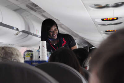 An American Airlines flight attendant serves drinks to passengers. Flight attendant unions and airlines continue to negotiate new contracts. (Robert Alexander/Getty Images)