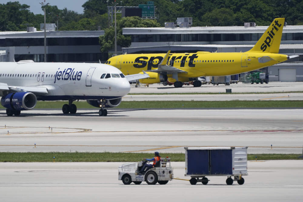A JetBlue Airways Airbus, left, passes a Spirit Airlines Airbus as it taxis on the runway. (Wilfredo Lee/AP)