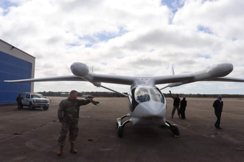 Joint Base Cape Cod Executive Director and Retired Brigadier General Christopher Faux stands in front of the fully-electric aircraft Alia after a demonstration at the 102nd Intelligence Wing. (Brian Engles/CAI)