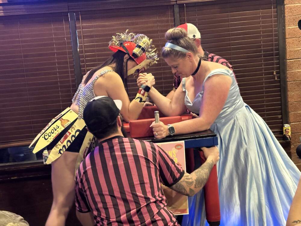 Two women face off at the Arm Wrestling Throwdown, a fundraising event for the Arizona chapter of the Pink Boots Society. The nonprofit raises is a networking group and raises funds to help women succeed in the beer and fermented alcoholic beverage industries. (Jill Ryan/KJZZ)