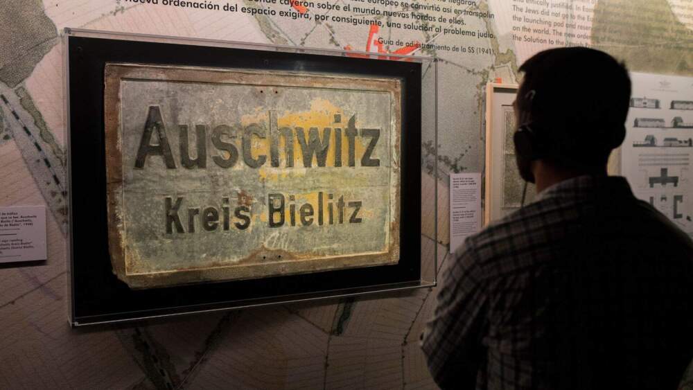 A visitor looks at a sign from Auschwitz. (Courtesy Musealia)