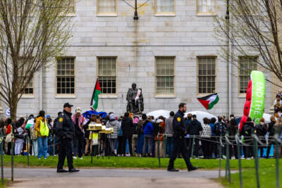 Harvard University police patrol the scene where protesters set up tents in front of the John Harvard Statue in Harvard Yard during a rally in support of the suspended pro-Palestinian group. (Jesse Costa/WBUR)
