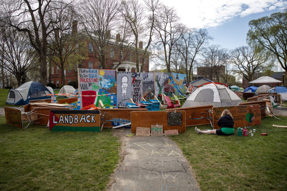 Tents and a protest mural at the student protest camp on the Green at Tufts University. (Robin Lubbock/WBUR)