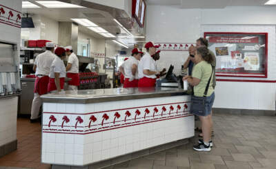 Customers place order at the counter of an In-N-Out burger restaurant Tuesday. (David Zalubowski/AP)