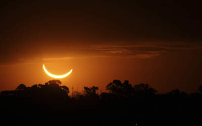 The moon passes in front of the setting sun during a total solar eclipse. (Marcos Brindicci/AP)