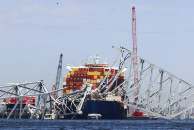 The collapsed Francis Scott Key Bridge lay on top of the container ship Dali, Monday, April 15, 2024, in Baltimore. The FBI confirmed that agents were aboard the Dali conducting court-authorized law enforcement activity. (Julia Nikhinson/AP)