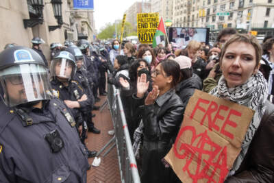 Police in Riot gear stand guard as demonstrators chant slogans outside the Columbia University campus. (Mary Altaffer/AP)
