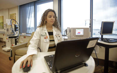 A nurse practitioner at the University of Miami, checks patients lab valves results. (Alan Diaz/AP)