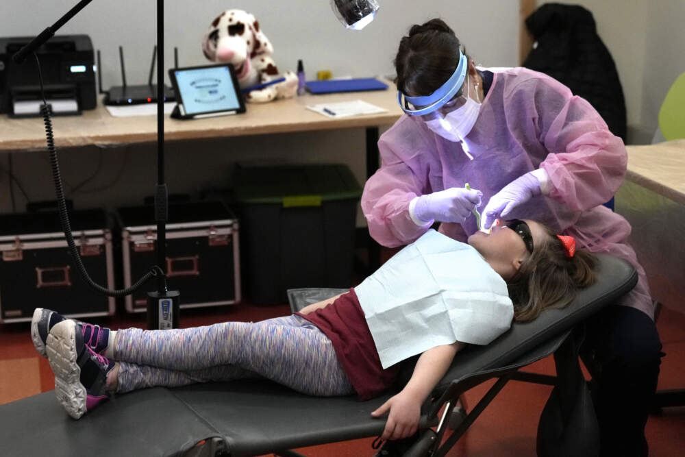 Dental hygienist Mary Davis examines Amber Warner's teeth at the Christa McAuliffe School. (Robert F. Bukaty/AP)