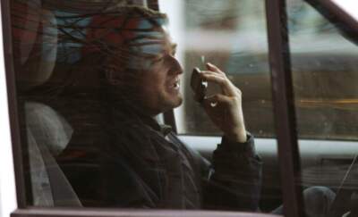 A driver talks on a cell phone while driving through Boston's Financial District. (Charles Krupa/AP)