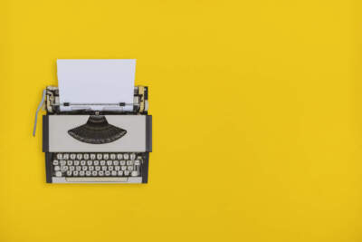 Overhead view of old typewriter on yellow background. (Getty Images)