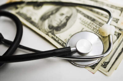 A stethoscope on top of a stack of money. (Doug4537/Getty Images)