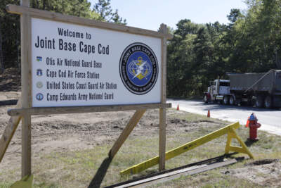 A truck drives past a welcome sign to Joint Base Cape Cod, in Sandwich, Mass. (Steven Senne/AP)