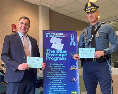 Massachusetts State Police Detective Lieutenant Kevin Baker (left) and Deputy Superintendent John Pinkham hold up new Blue Envelopes. (Massachusetts State Police)