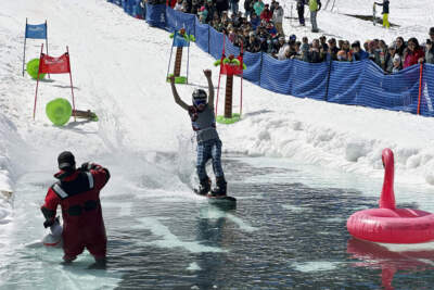 A snowboarder participates in a pond skimming event at Gunstock Mountain Resort, in Gilford, N.H. The wacky spring tradition is happening this month at ski resorts across the country and is often held to celebrate the last day of the skiing season. (Nick Perry/AP)