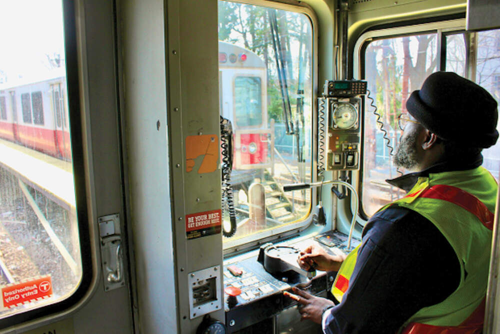 Peterson Desir behind the controls of a Red Line car near Ashmont station. The 33-year-old motorman is one of 23 new heavy rail drivers who have taken jobs at the agency in recent months.
