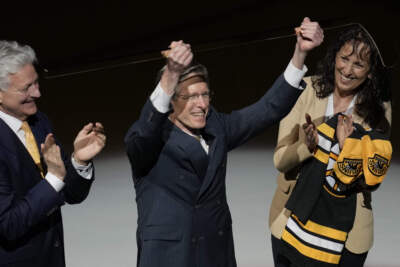 Boston Bruins television play-by-play announcer Jack Edwards, center, holds up a golden stick in honor of his announced retirement, before the Bruins' NHL hockey game against the Ottawa Senators, Tuesday, April 16, 2024, in Boston. (Charles Krupa/AP)