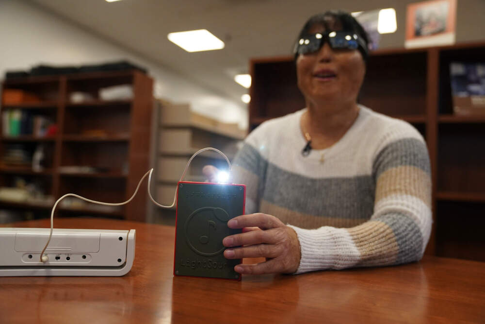 Minh Ha, assistive technology manager at the Perkins School for the Blind tries a LightSound device for the first time at the school's library in Watertown, Mass., on March 2, 2024. (Mary Conlon/AP)
