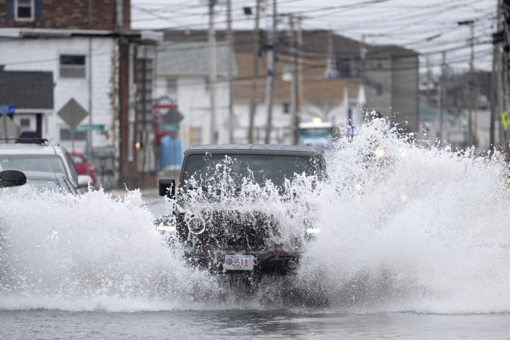 A motorist plows through a flooded road during a winter storm, Tuesday, Feb. 13, 2024, in Hampton Beach, N.H. (Robert F. Bukaty/AP)