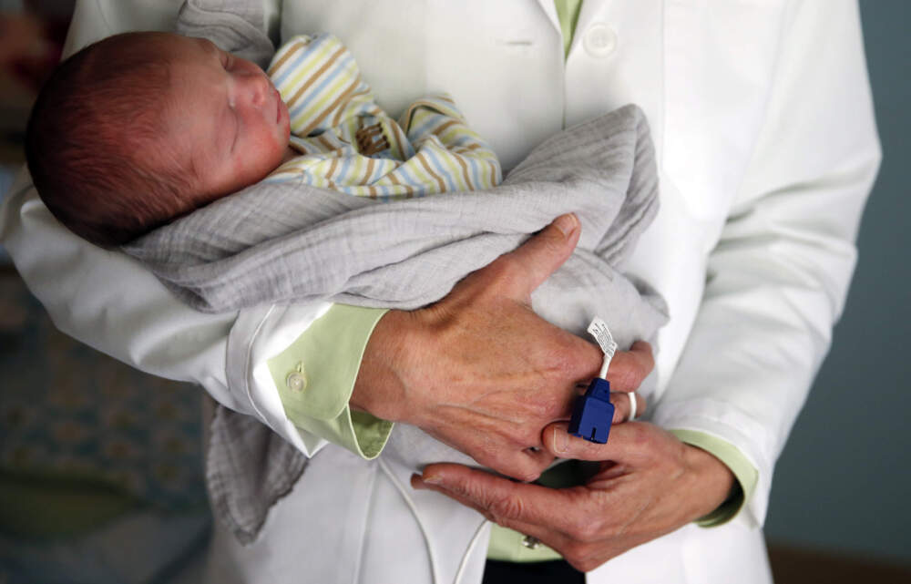 A pediatric doctor holds a baby being treated for symptoms of withdrawal at Cape Cod Hospital in Hyannis, Mass. in 2016. (Jessica Rinaldi/The Boston Globe via Getty Images)