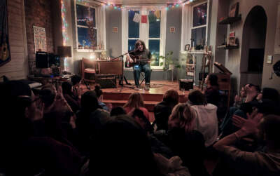Berklee student Mae Valerio performs a concert in their apartment. (Elijah Nicholson-Messmer for WBUR)