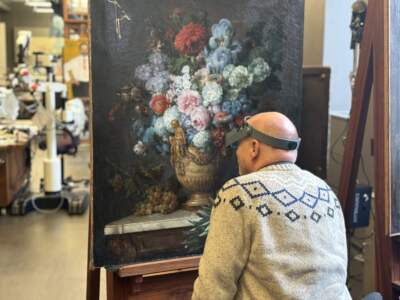 Michael Swicklik is senior conservator at the National Gallery in Washington, DC. Here, he's working to restore a newly discovered painting by 18th-century artist Anne Vallayer-Coster. (Elliot Williams/WAMU)