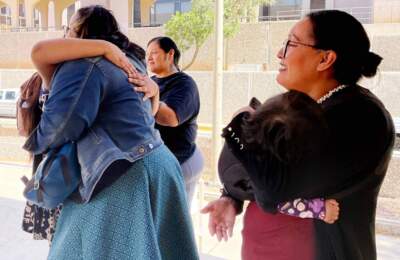 Indivisible Tohono leaders April Ignacio, left, and Elayne Gregg, right, holding her baby daughter Siku, cried and hugged supporters outside city hall on Tuesday. (Courtesy of Chelsea Curtis)