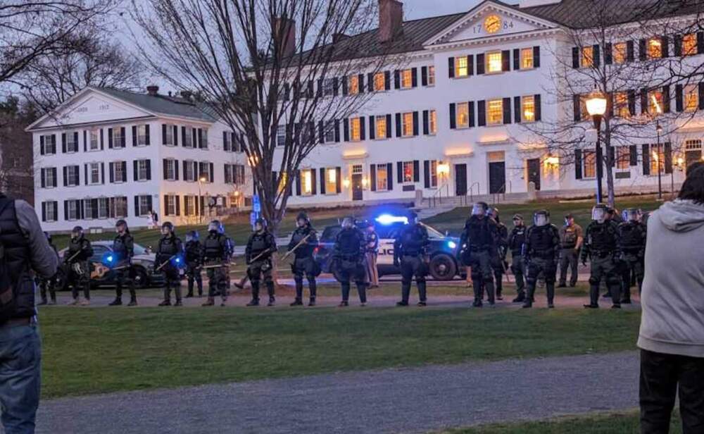 State police line the perimeter of the Dartmouth Green as a crowd gathered to protest Israel's war in Gaza Wednesday night. (Olivia Richardson/NHPR)
