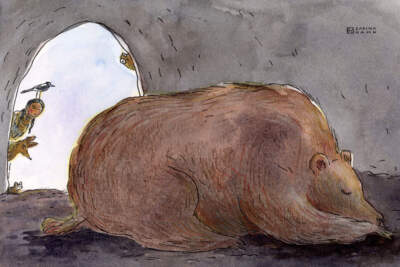 A girl looks into a cave with a sleeping bear. (Sabina Hahn for WBUR)